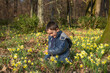 © AUFORT Jérome - young boy picking daffodils in forest