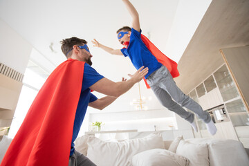 Wall Mural - Father holding son in superhero costume