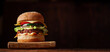 Hamburger on a dark wooden background. Banner. Place for text. Hamburger day concept.