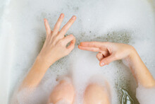 Female Masturbation, Bathroom Sex Concept. Female Hands In A Bath With Foam Depict Erotic Gestures. Sexual Gratification In The Bath.