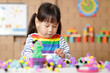 © M-image - young girl playing creative building ball toy at home
