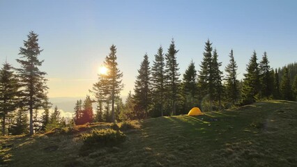 Wall Mural - Aerial view of tourist camping tent on mountain campsite at bright sunny evening. Active tourism and hiking concept