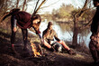 © Cavan Images - Young strong alternative friends make a fire riverside