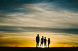 © Cavan Images - Four siblings silhouettes by summer golden sunset