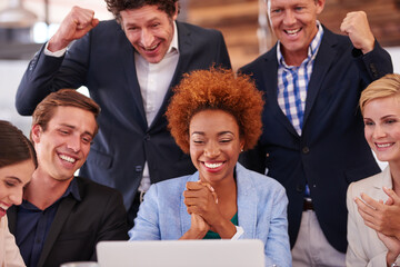 Poster - Celebrating the good news. Cropped shot of a group of businesspeople gathered around a single laptop.