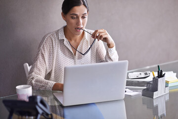 Poster - solving the problem. shot of a beautiful young business woman thinking at her desk.