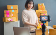 © sutthinon602 - Beautiful asian woman blogger showing clothes in front of camera to recording vlog video live streaming at her shop. Business online influencer on social media concept. Online Selling. Online Shopping