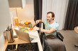 © Svitlana - Adult man in a wheelchair preparing food and using laptop
