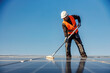 A worker maintain solar panel on the roof.