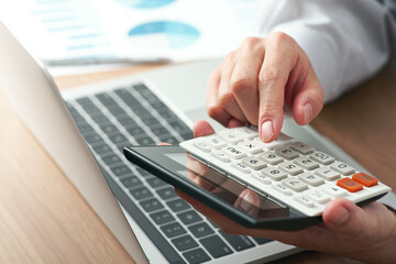 Aufkleber - Working with calculator. Close up of hands. Laptop and reports on desk. Finance and calculating image.