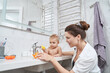 © Viacheslav Yakobchuk - Cute little kid sitting in washbasin while playing with bath toys in room indoors
