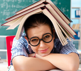 Wall Mural - The female student with many books sitting in the classroom