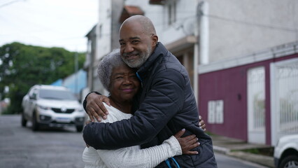 Wall Mural - A Brazilian son embracing a senior mother in 80s outside portrait