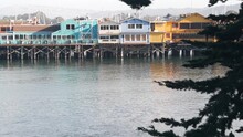 Colorful Wooden Houses On Piles, Pillars Or Pylons, Ocean Sea Water, Historic Old Fisherman's Wharf, Monterey Bay Or Harbor, California Coast USA. Tourist Beachfront Promenade, Waterfront Boardwalk.
