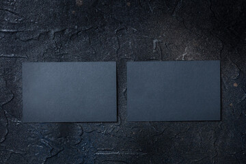 Two black business cards mockup, front and back, on a dark background, a template for design presentation, thick cardboard