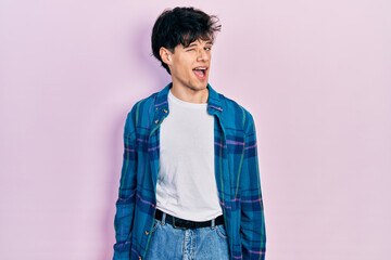 Canvas Print - Handsome hipster young man wearing casual white t shirt and vintage shirt winking looking at the camera with sexy expression, cheerful and happy face.