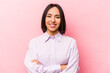 © Asier - Young hispanic woman isolated on pink background who feels confident, crossing arms with determination.