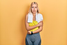 Beautiful Blonde Sports Woman Wearing Workout Outfit Shaking And Freezing For Winter Cold With Sad And Shock Expression On Face