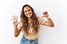 Beautiful Hispanic Woman Standing Over Isolated While Background Showing And Pointing Up With Fingers Number Six While Smiling Confident And Happy.
