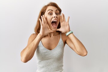 Canvas Print - Beautiful caucasian woman standing over isolated background smiling cheerful playing peek a boo with hands showing face. surprised and exited