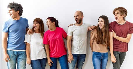 Sticker - Group of young friends standing together over isolated background angry and mad screaming frustrated and furious, shouting with anger. rage and aggressive concept.