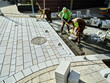 © Westend61 - Pavers working on footpath to install paving stones
