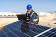 © Westend61 - Technician with laptop working at solar power station