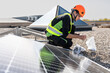© Westend61 - Technician assembling and installing solar panels on sunny day
