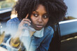 © Westend61 - Curly haired woman talking on smart phone sitting in car