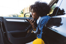 Cheerful Woman Talking On Mobile Phone Through Speaker Sitting In Car