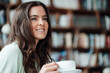 © Westend61 - Smiling woman with coffee cup day dreaming in cafe