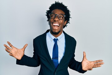 Poster - Young african american man wearing business suit crazy and mad shouting and yelling with aggressive expression and arms raised. frustration concept.