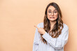 © Asier - Young caucasian woman isolated on beige background pointing to the side