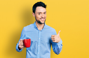 Poster - Hispanic man with beard drinking a cup coffee smiling happy and positive, thumb up doing excellent and approval sign