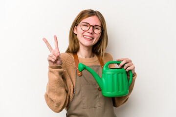 Young gardener woman holding a sprinkler isolated on white background showing number two with fingers.