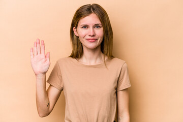 Young English woman isolated on beige background smiling cheerful showing number five with fingers.