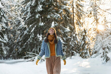 Woman Wearing Warm Clothing Walking In Winter Forest