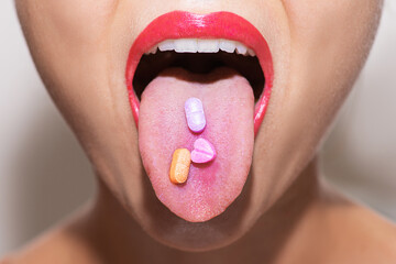 Wall Mural - Female face with colorful vitamin or drug pills on her tongue
