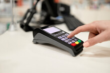 Hand using credit card reader at checkout counter in store