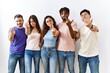 © Krakenimages.com - Group of young people standing together over isolated background showing middle finger, impolite and rude fuck off expression