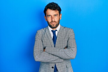 Sticker - Handsome man with beard wearing business suit and tie skeptic and nervous, disapproving expression on face with crossed arms. negative person.