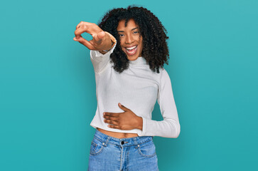 Wall Mural - Young african american girl wearing casual clothes laughing at you, pointing finger to the camera with hand over body, shame expression