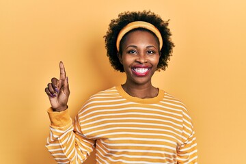 Wall Mural - Young african american woman wearing casual sweatshirt smiling with an idea or question pointing finger up with happy face, number one