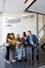 Wall Mural - Group of positive businesspeople standing together in the office