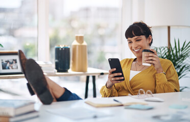 Poster - Coffee and technology go hand in hand. Cropped shot of an attractive young businesswoman sitting with her feet up in her office and using her cellphone.