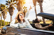 © Xavier Lorenzo - Happy young couple having enjoying summer vacation on convertible car - Man and woman laughing while driving a cabriolet auto outdoors - Travel, car rental service and holidays concept