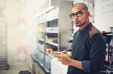 Poster - Social media plays a serious role in advertising. Shot of a man using his cellphone while standing in a coffee shop.