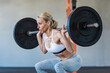 © Tetra Images - Athlete woman exercising with barbell