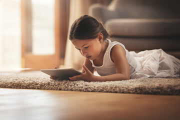 Poster - Educational apps right at her fingertips. Shot of an adorable little girl using a digital tablet on the floor at home.