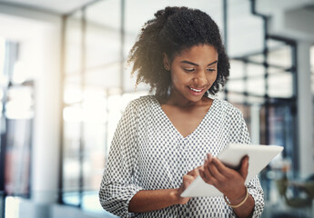 Poster - Pushing business further the smart way. Shot of a young businesswoman using a digital tablet in an office.